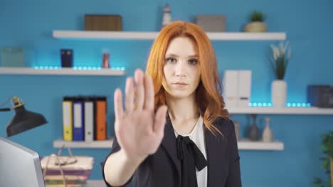 Businesswoman-looking-at-camera-making-stop-sign-with-hand.